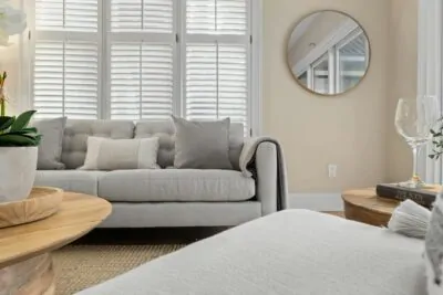 Coastal luxe living room with linen sofa, driftwood and warm white walls