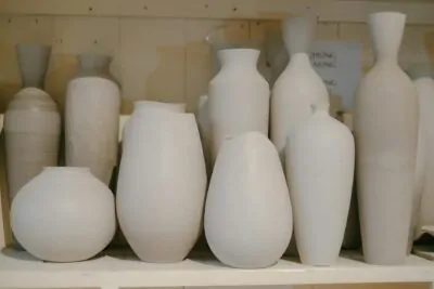Handmade ceramic vases styled on an open wood shelf