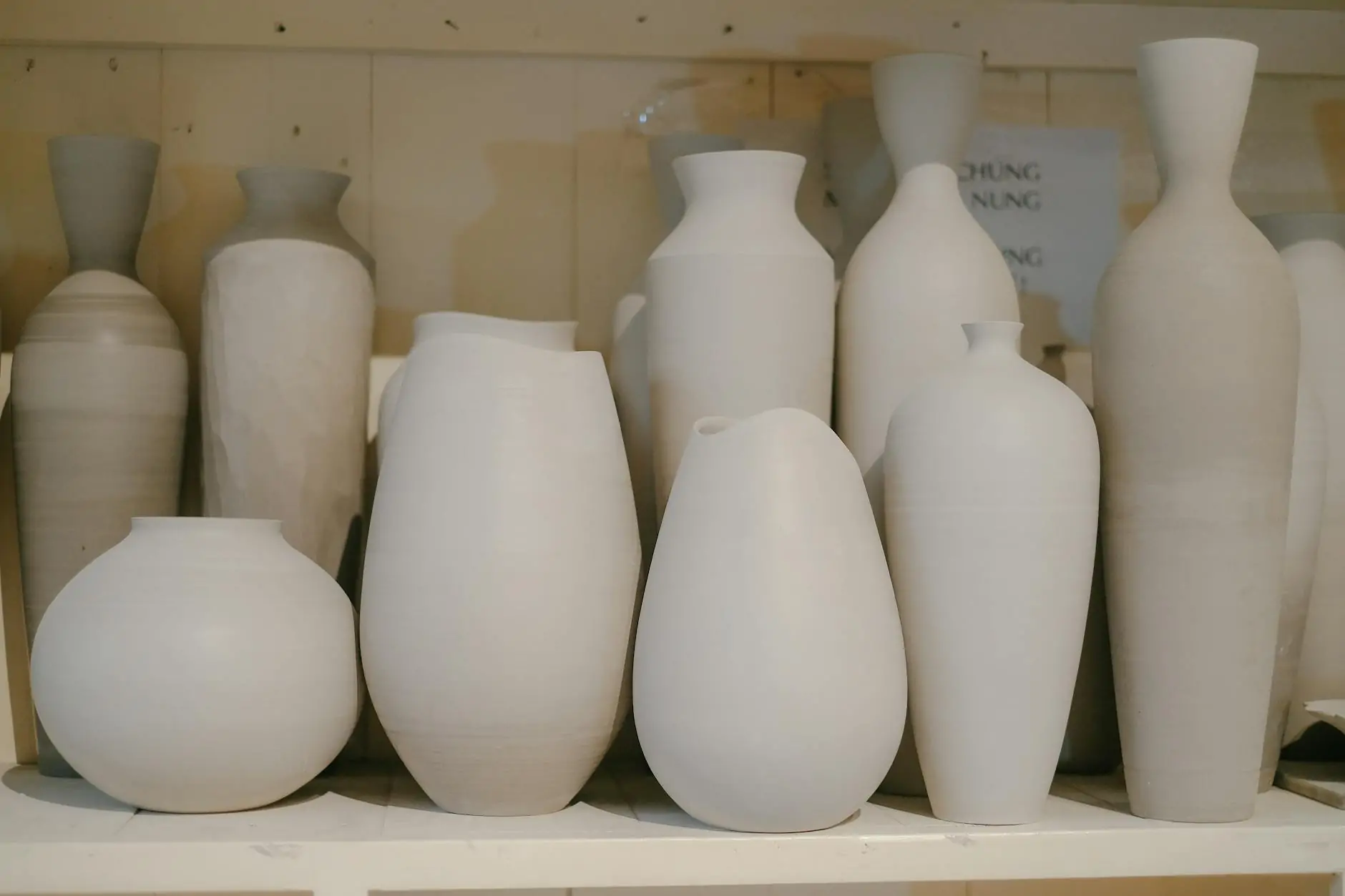 Handmade ceramic vases styled on an open wood shelf