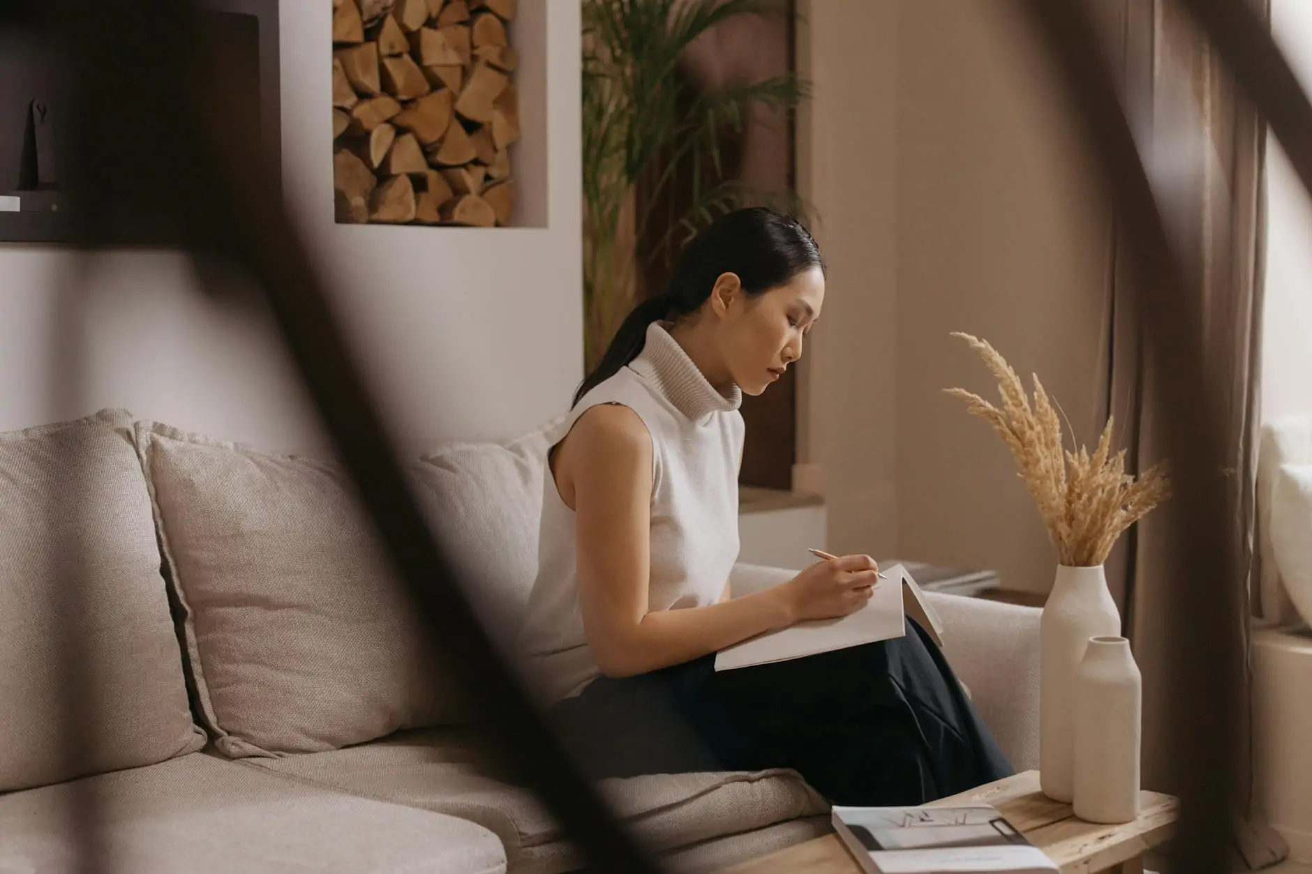 Japandi interior design living room with low oak sofa, linen textures and paper lantern