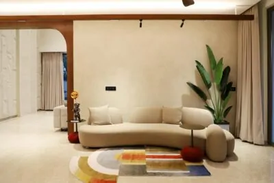 Organic modern living room with curved cream sofa, oak and travertine