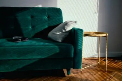 Emerald green velvet sofa in a curated living room