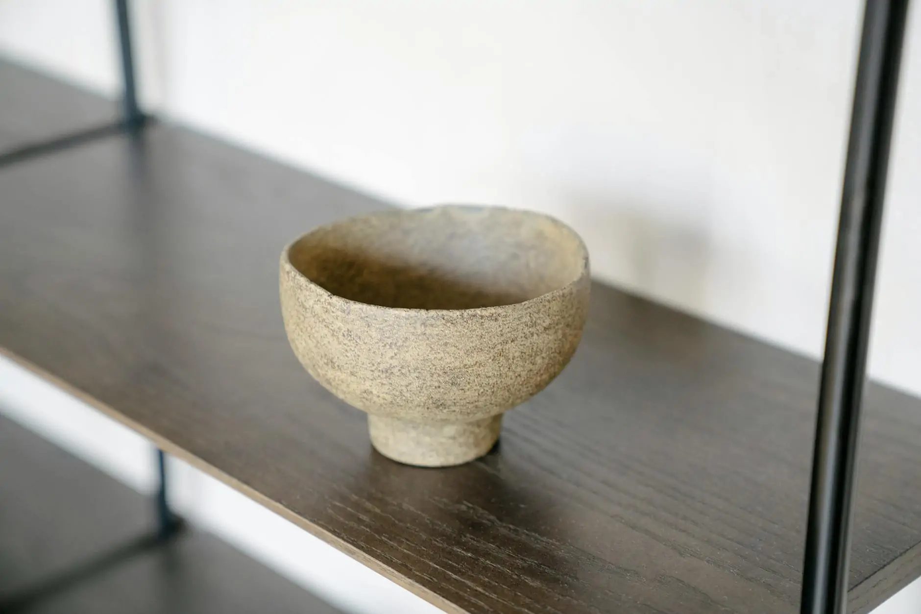 Wabi sabi interior with raw plaster wall, handmade ceramic and aged wood table