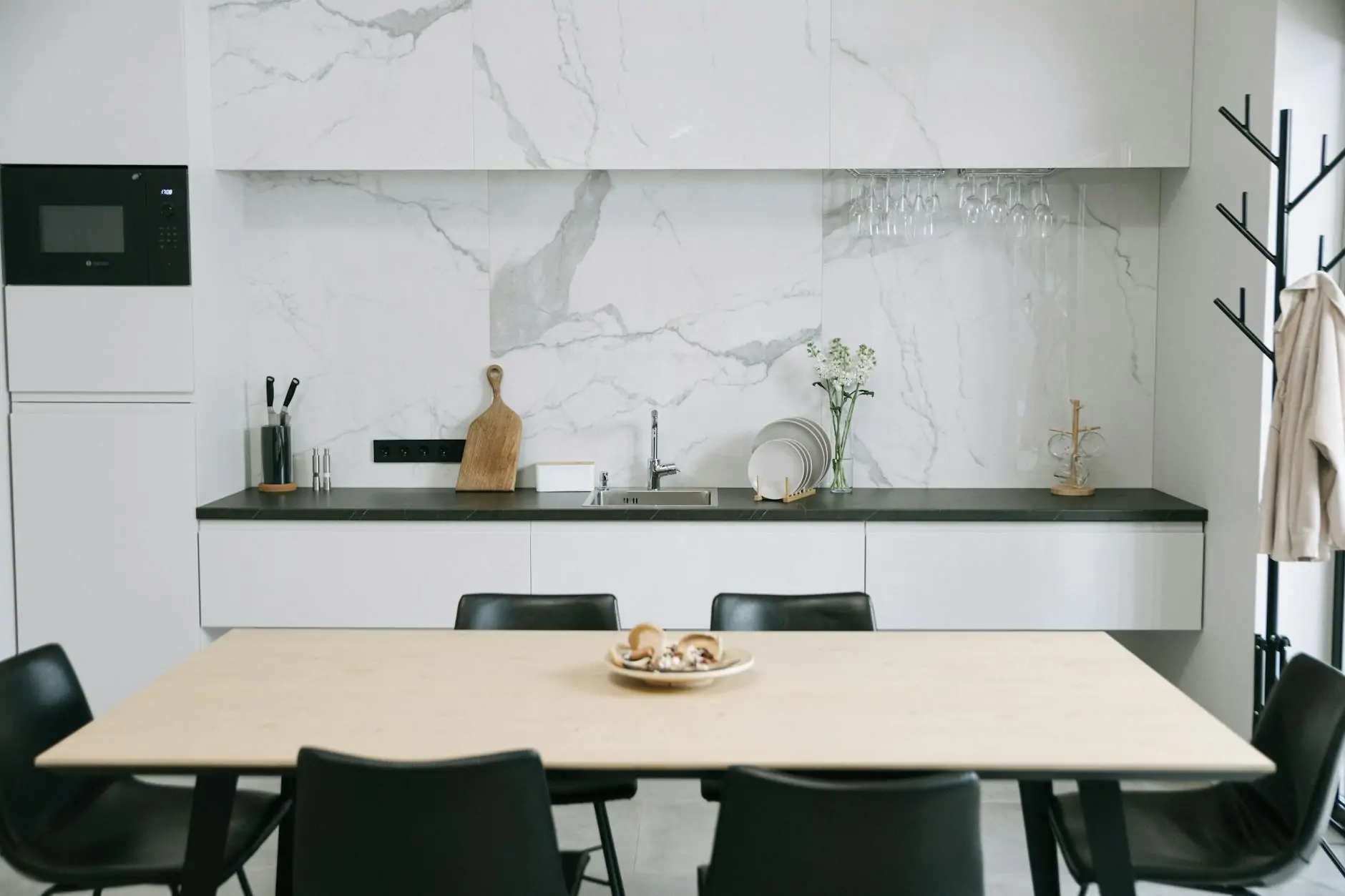 White kitchen with marble counters and oak floors