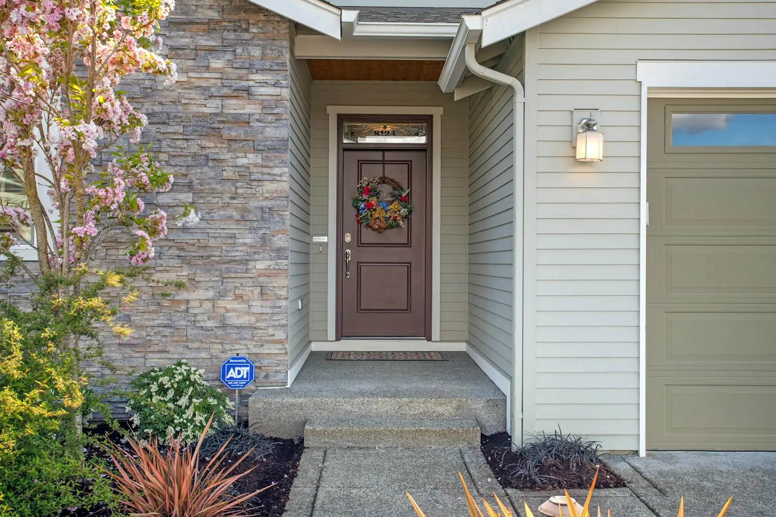 Well maintained house entry with front door, path, and plants