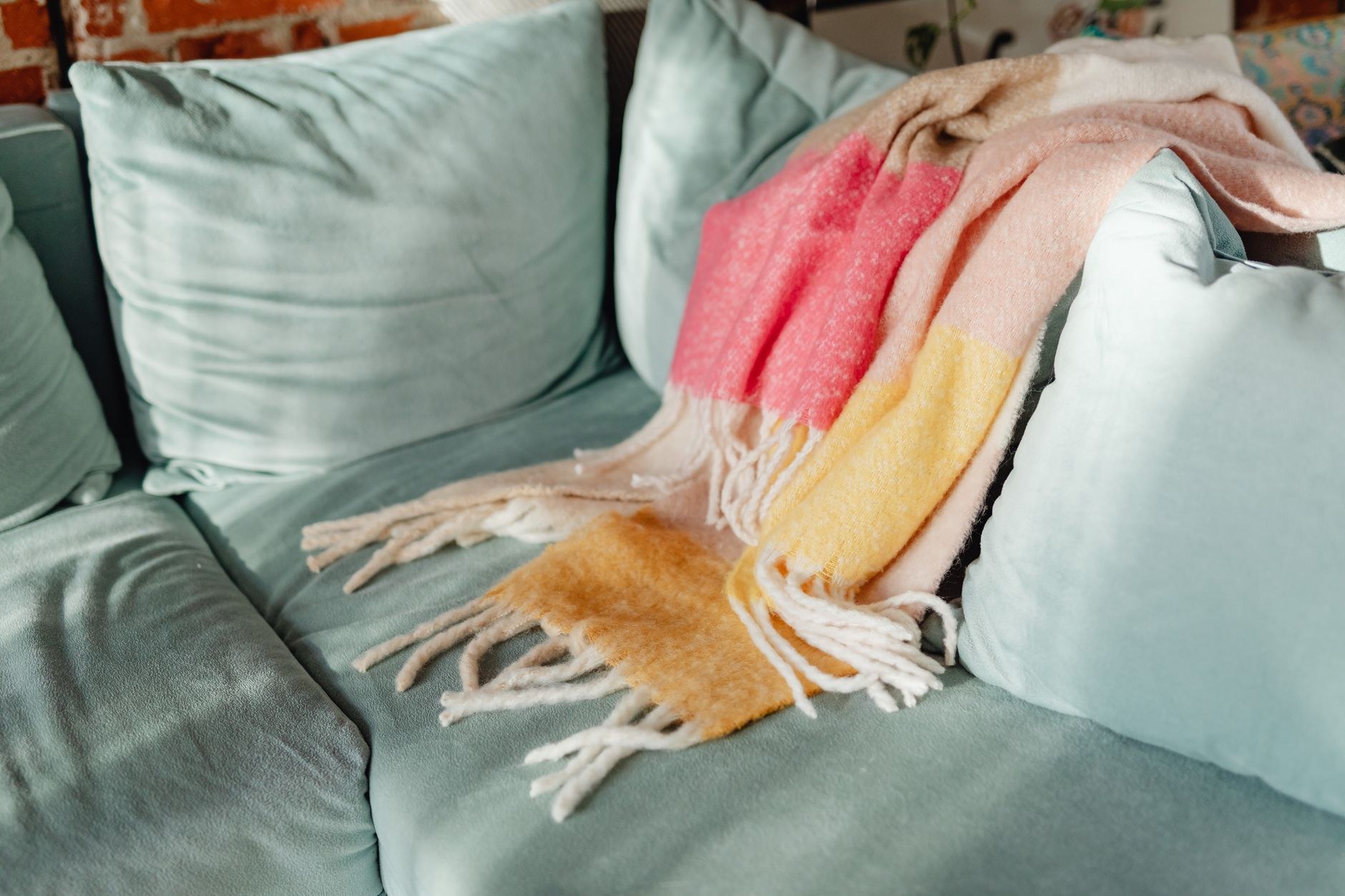 Colorful standard throw blanket draped across a sofa arm