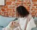 Adult wrapped in an oversized blanket while sitting on a sofa