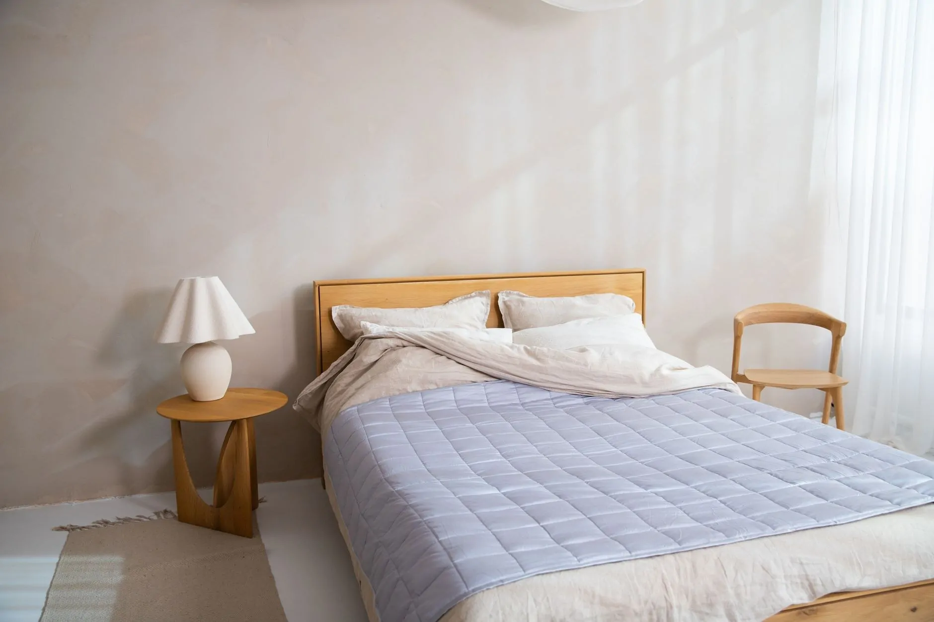 Large blanket layered across a simple platform bed