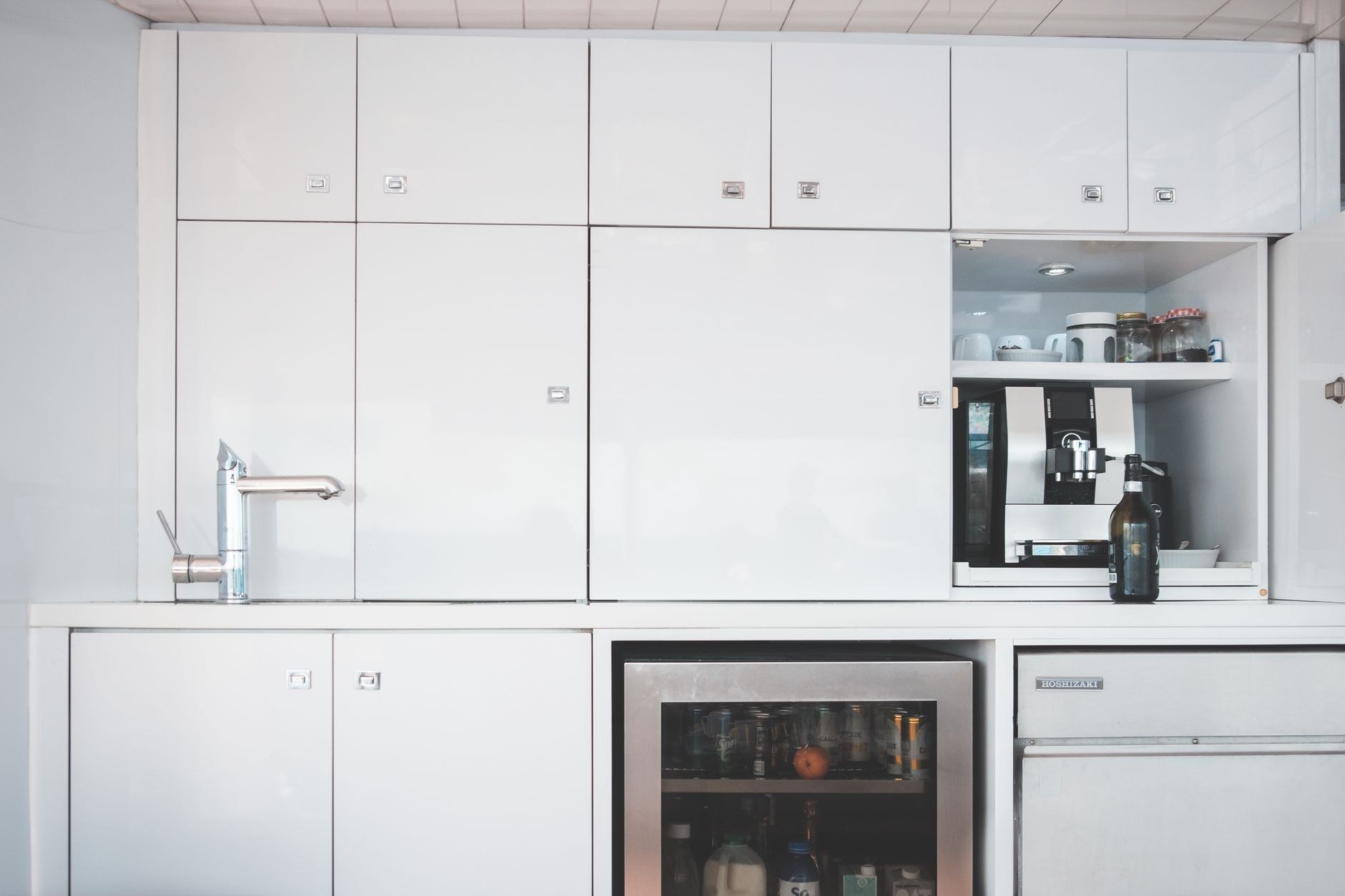 Kitchen cabinetry with a recessed coffee station and clear work surface