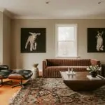 Black Eames-style lounge chair with molded wood shell and leather cushions in a living room
