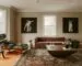 Black Eames-style lounge chair with molded wood shell and leather cushions in a living room