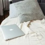 Lightweight cooling blanket folded across a neutral summer bed