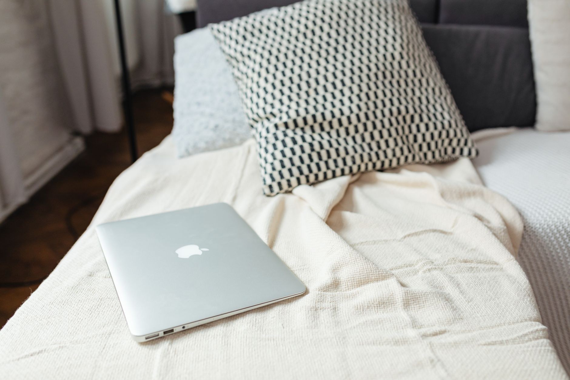 Lightweight cooling blanket folded across a neutral summer bed