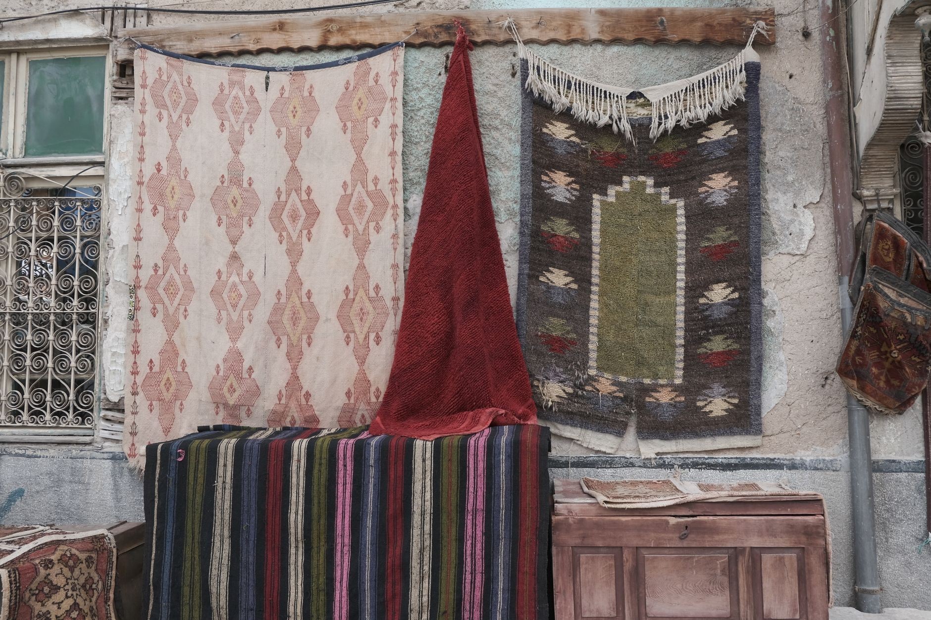 Traditional woven rugs hanging vertically across an exterior wall