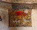A vintage woven rug displayed vertically on a rustic interior wall