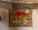 A vintage woven rug displayed vertically on a rustic interior wall