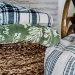 Folded oversized throws stored in a woven living room basket