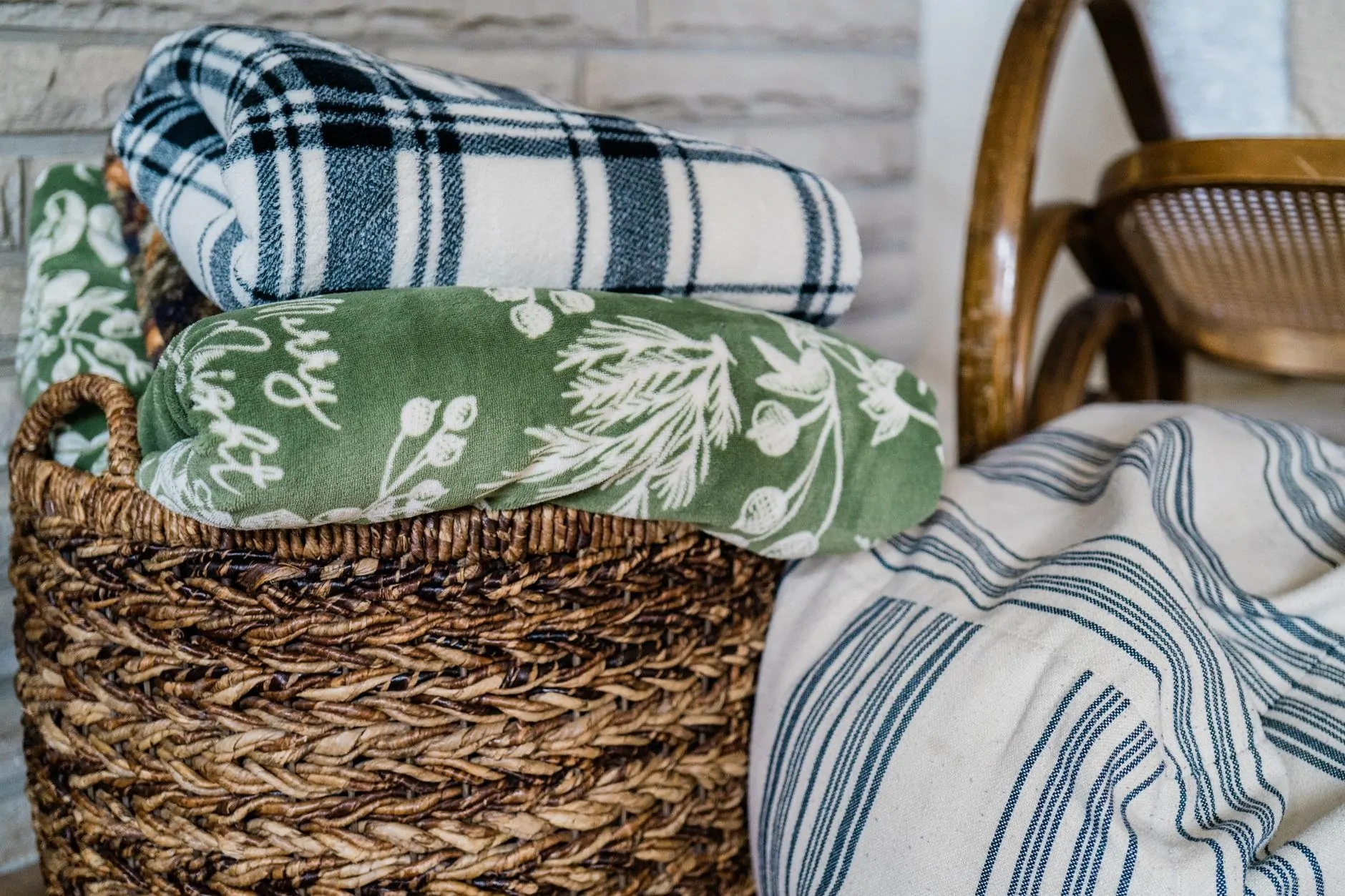 Folded oversized throws stored in a woven living room basket
