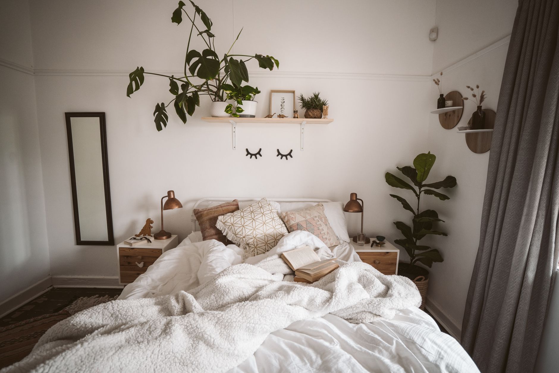 Cozy bedroom with layered white blankets and pillows on the bed