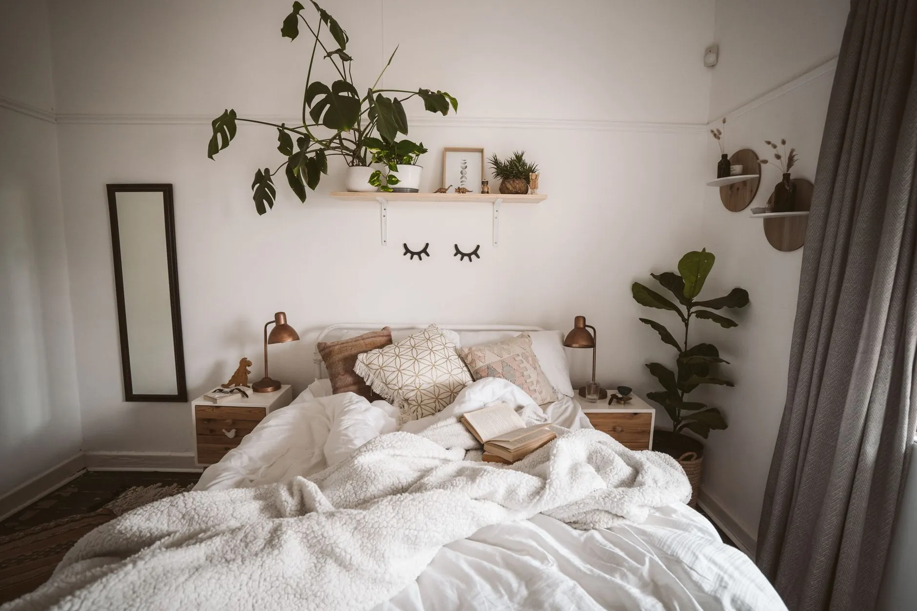 Cozy bedroom with layered white blankets and pillows on the bed