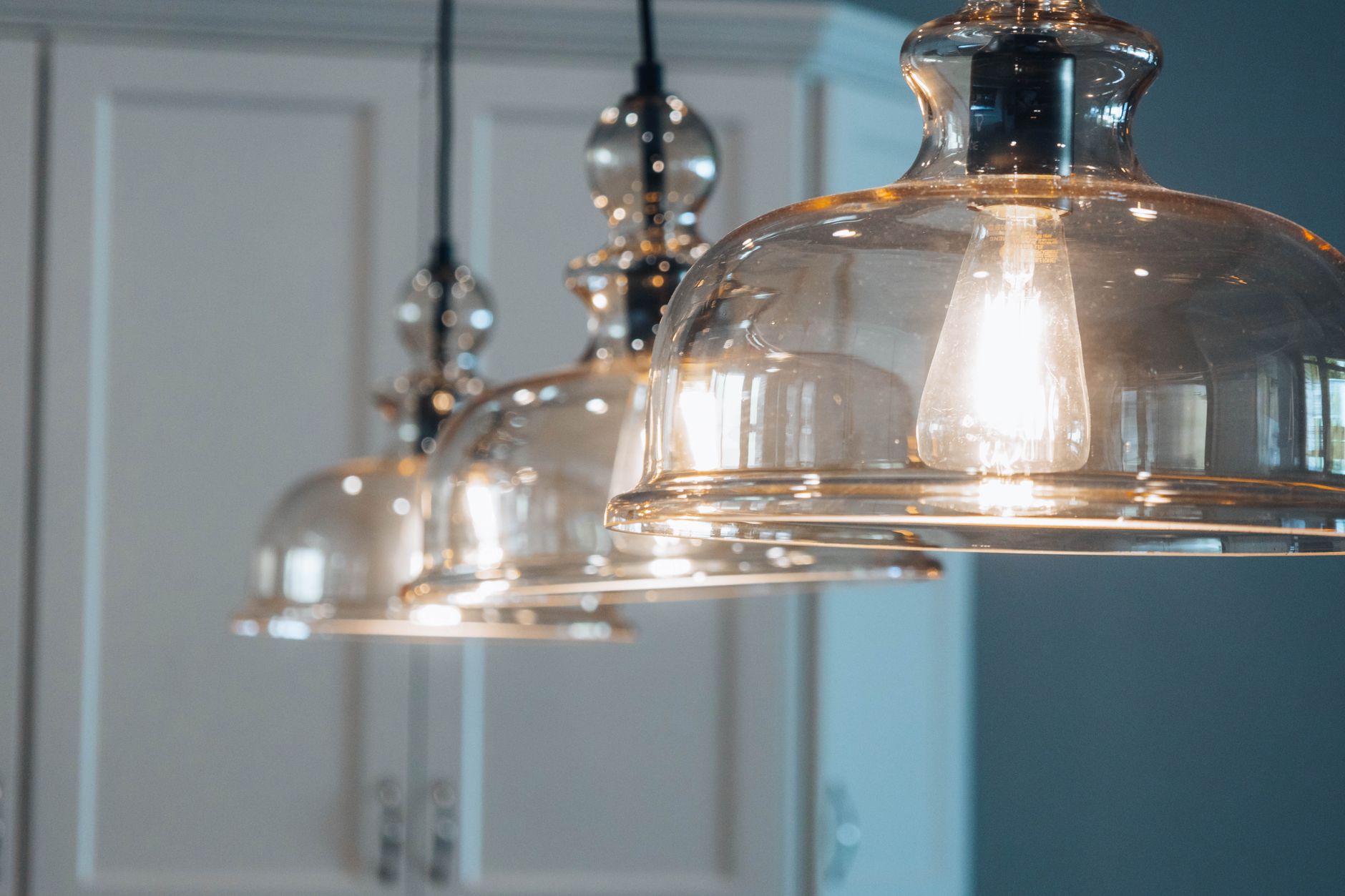 Close-up of illuminated bulbs inside clear glass pendant shades