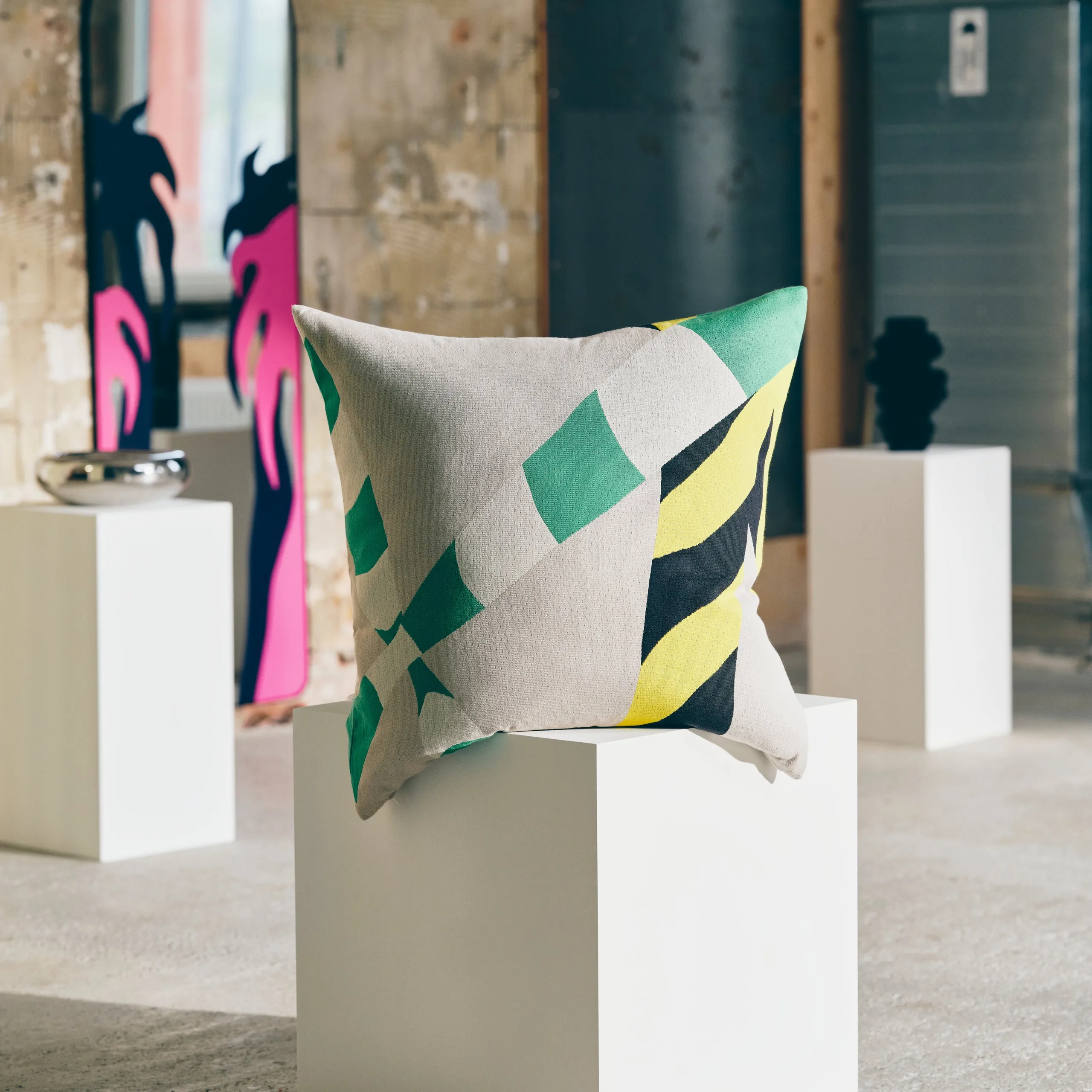 KONSTRUNDA patterned floor cushion and decorated full-length mirror in a gallery setting