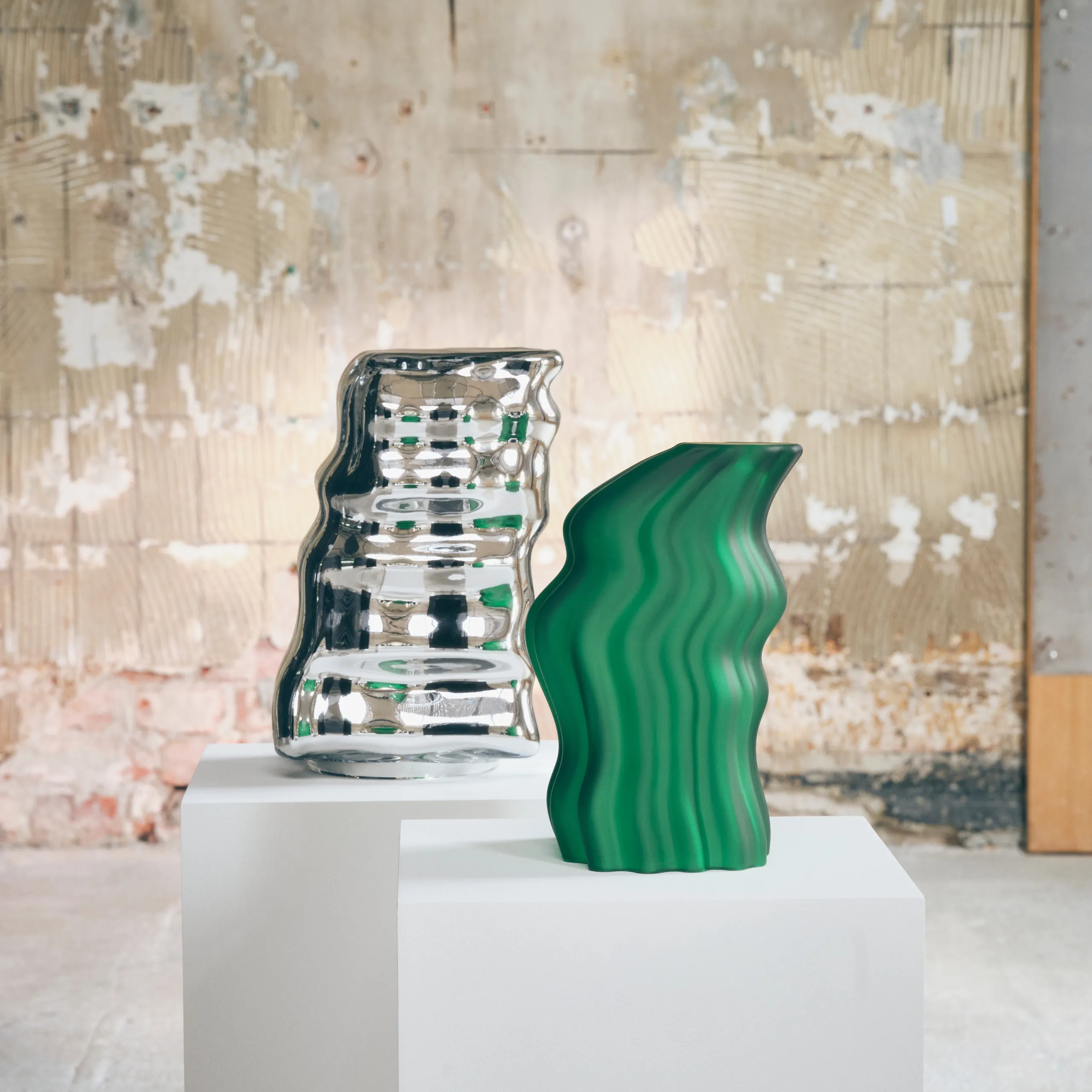 Green and silver KONSTRUNDA glass sculptures on a white plinth