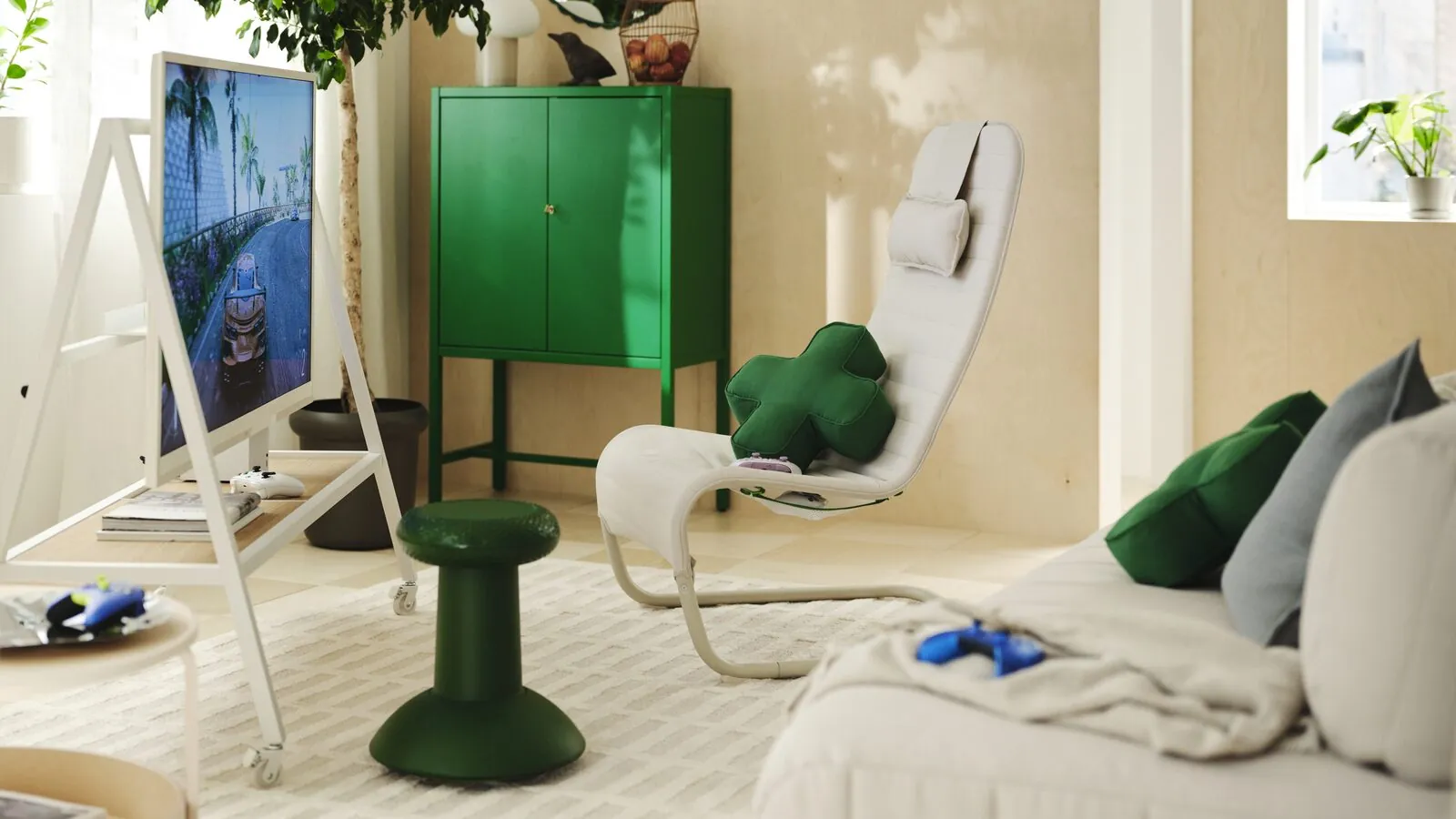 A living room gaming setup with a YXSTABY gaming chair, thumbstick stool, TV stand and D-pad-inspired cushions