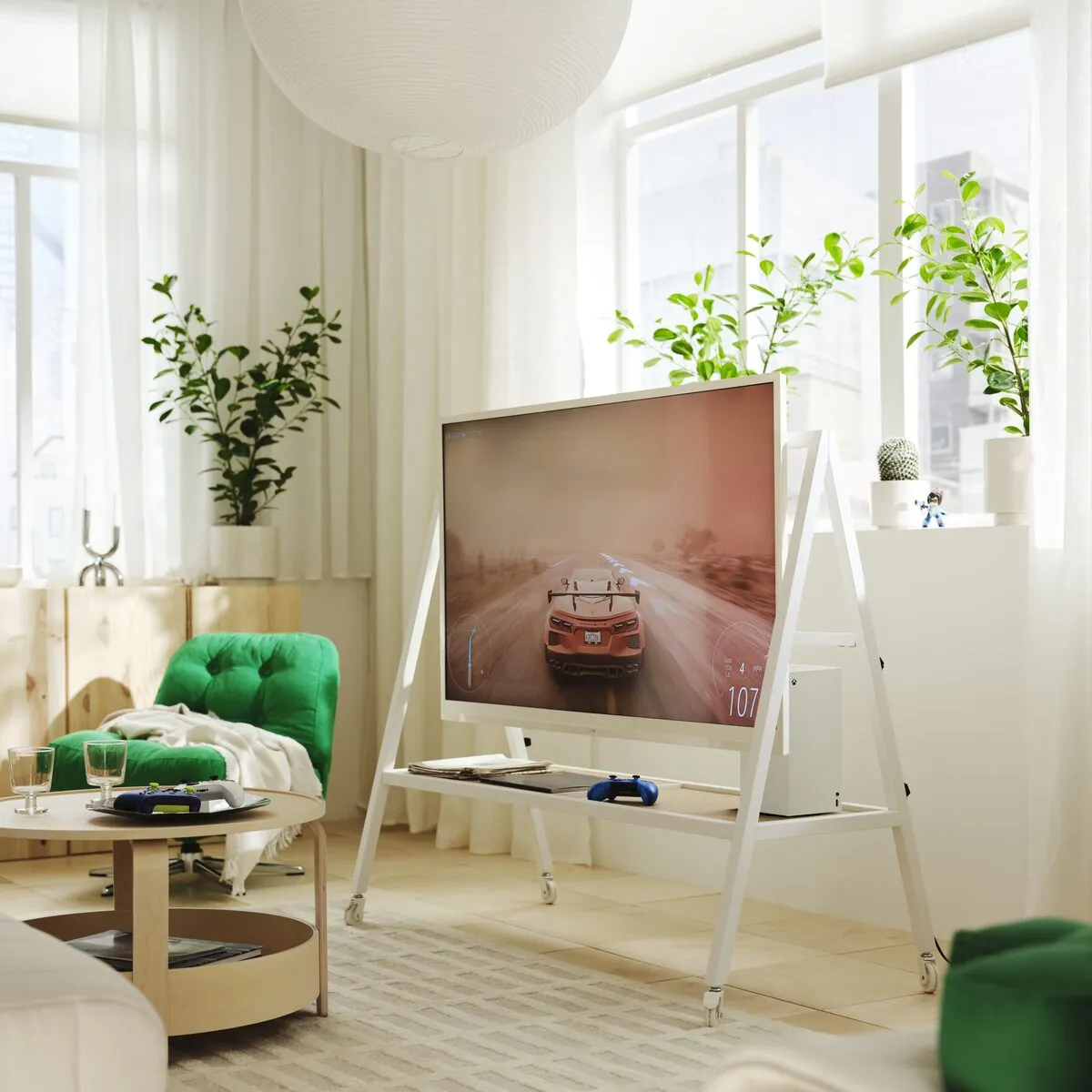 White YXSTABY TV stand holding a television, gaming console and accessories in a living room