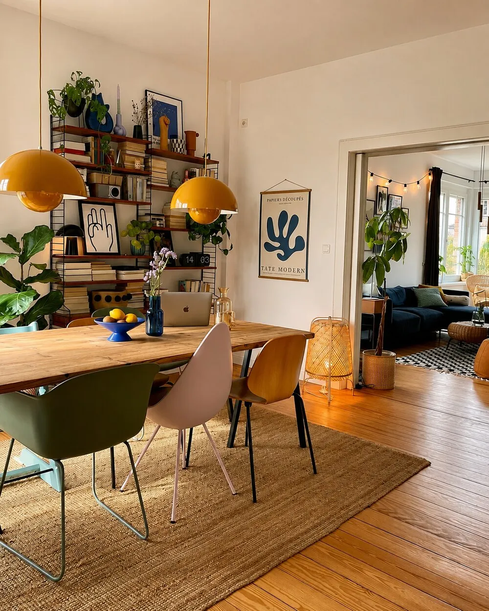 A warm, eclectic dining room with colourful chairs and mustard lamps