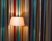 Striped curtains and a lit floor lamp illustrating color, light, and movement in an interior
