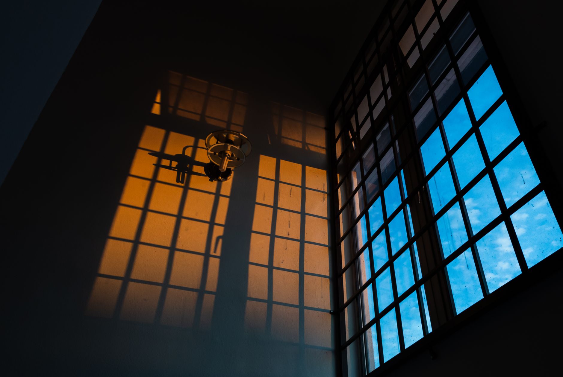 Blue and orange window shadows changing the appearance of an interior wall