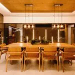 Dining room illuminated by warm pendant lighting above a wooden table