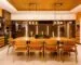 Dining room illuminated by warm pendant lighting above a wooden table