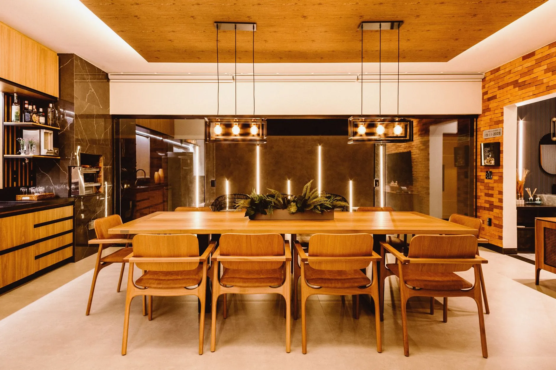 Dining room illuminated by warm pendant lighting above a wooden table
