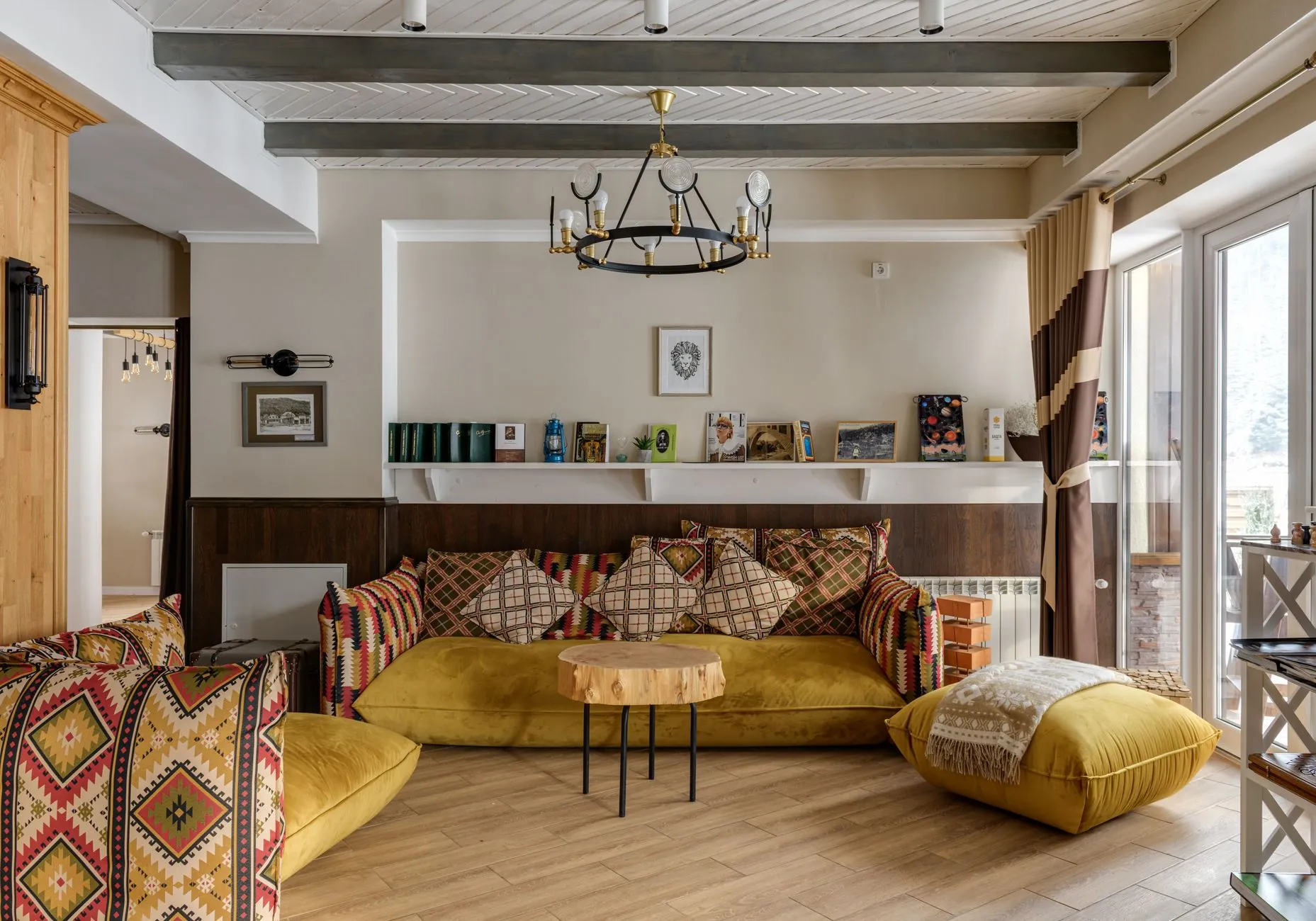 Eclectic living room with a patterned sofa, yellow seating, books, a round table, and mixed lighting