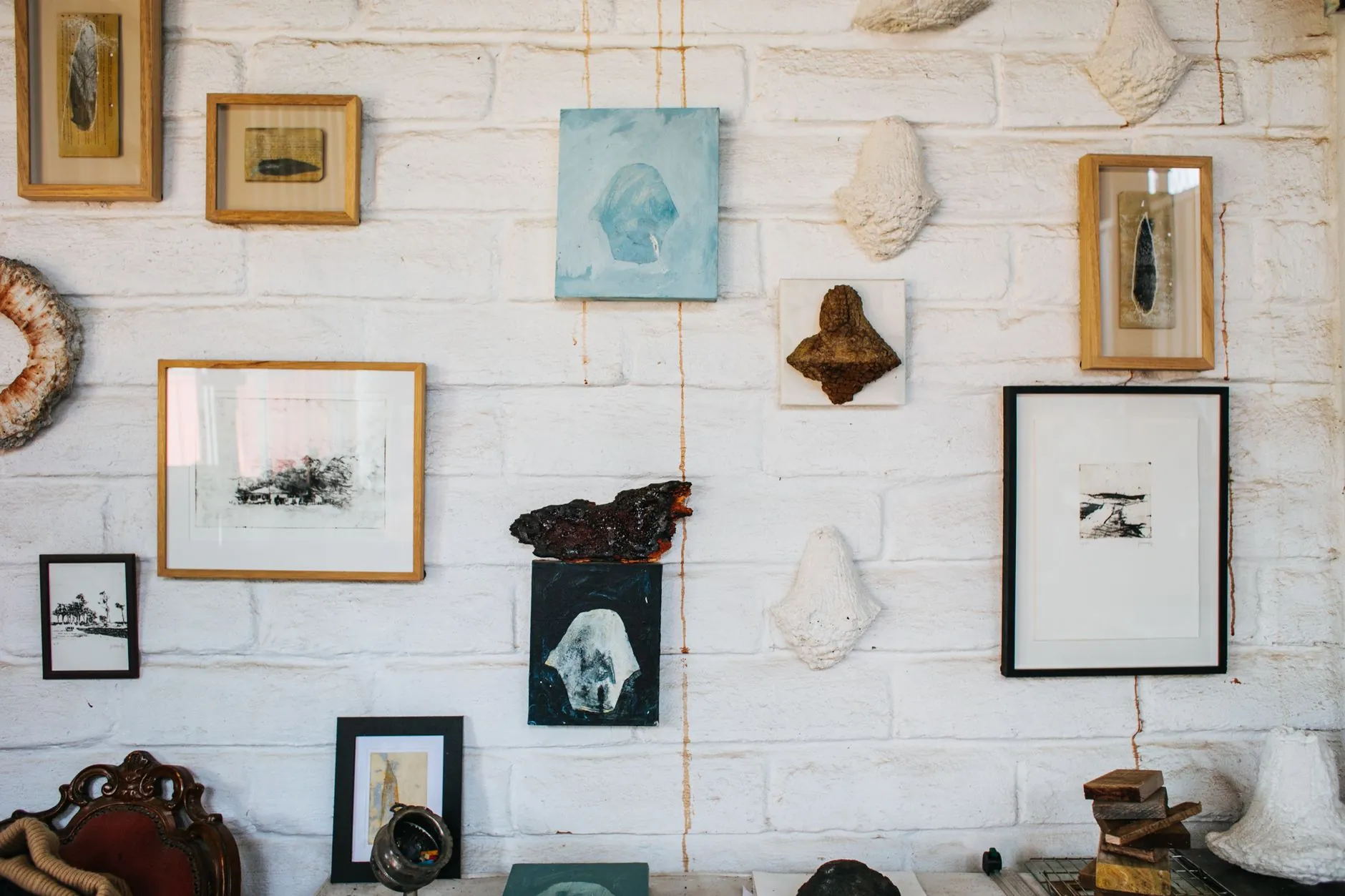 Gallery wall with framed pictures arranged across a white brick wall