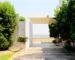 A modern garden entrance framed by clipped greenery and pale paving