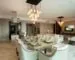 Open-plan dining and living area with pendant clusters, recessed ceiling lights and a floor lamp