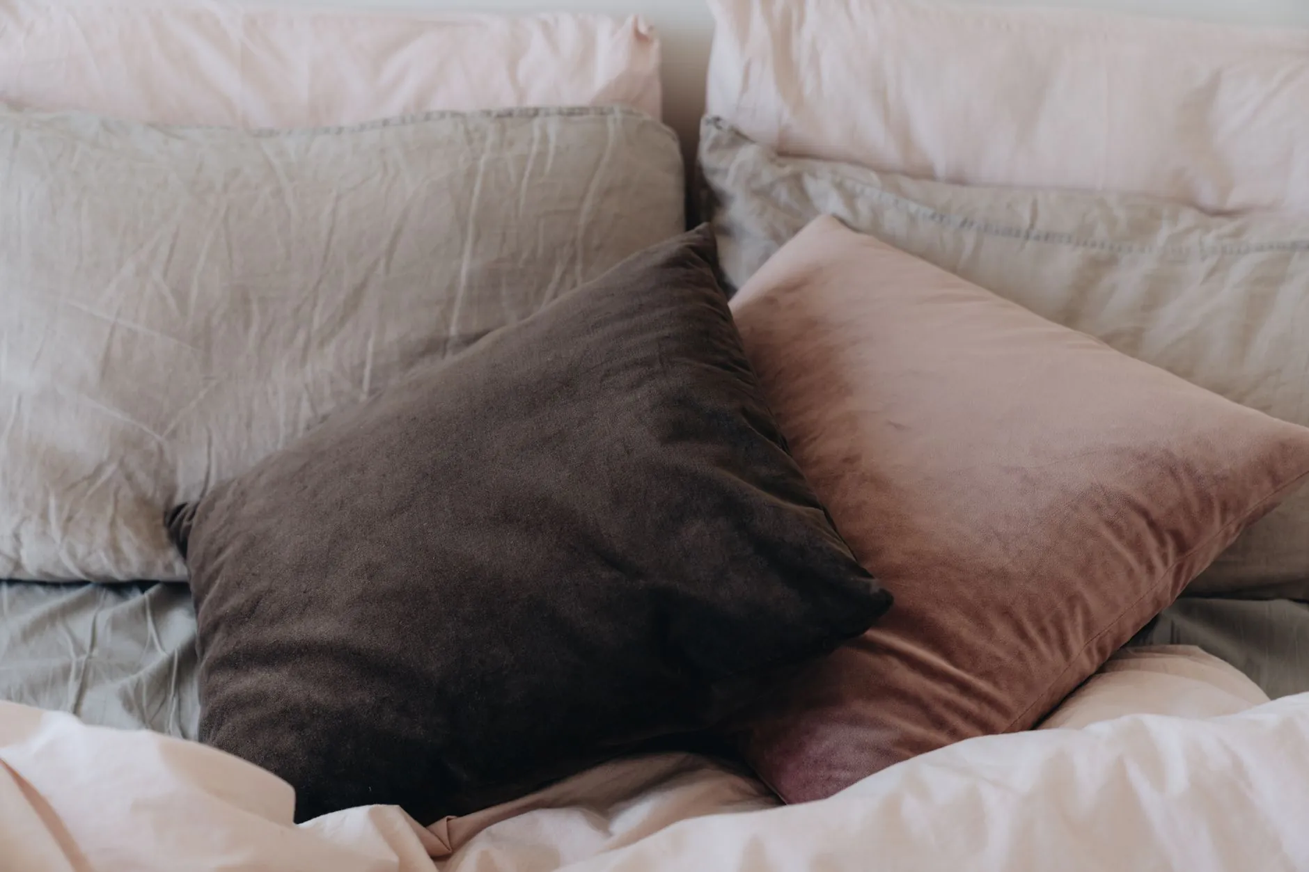Layered pillows and bedding on a neatly made bed