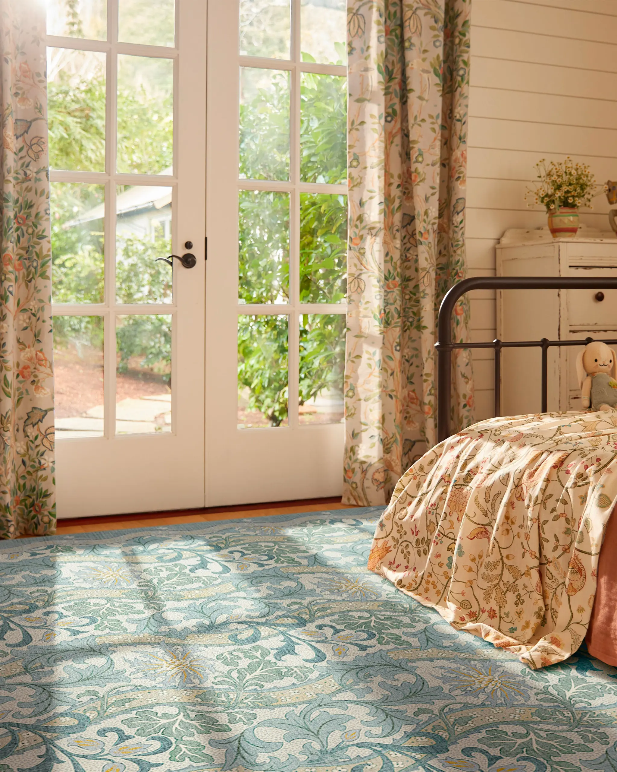 Cornflower Slate Blue rug by Morris and Co in a softly patterned bedroom