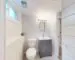 Small bright bathroom with a compact vanity, toilet, and clear floor space