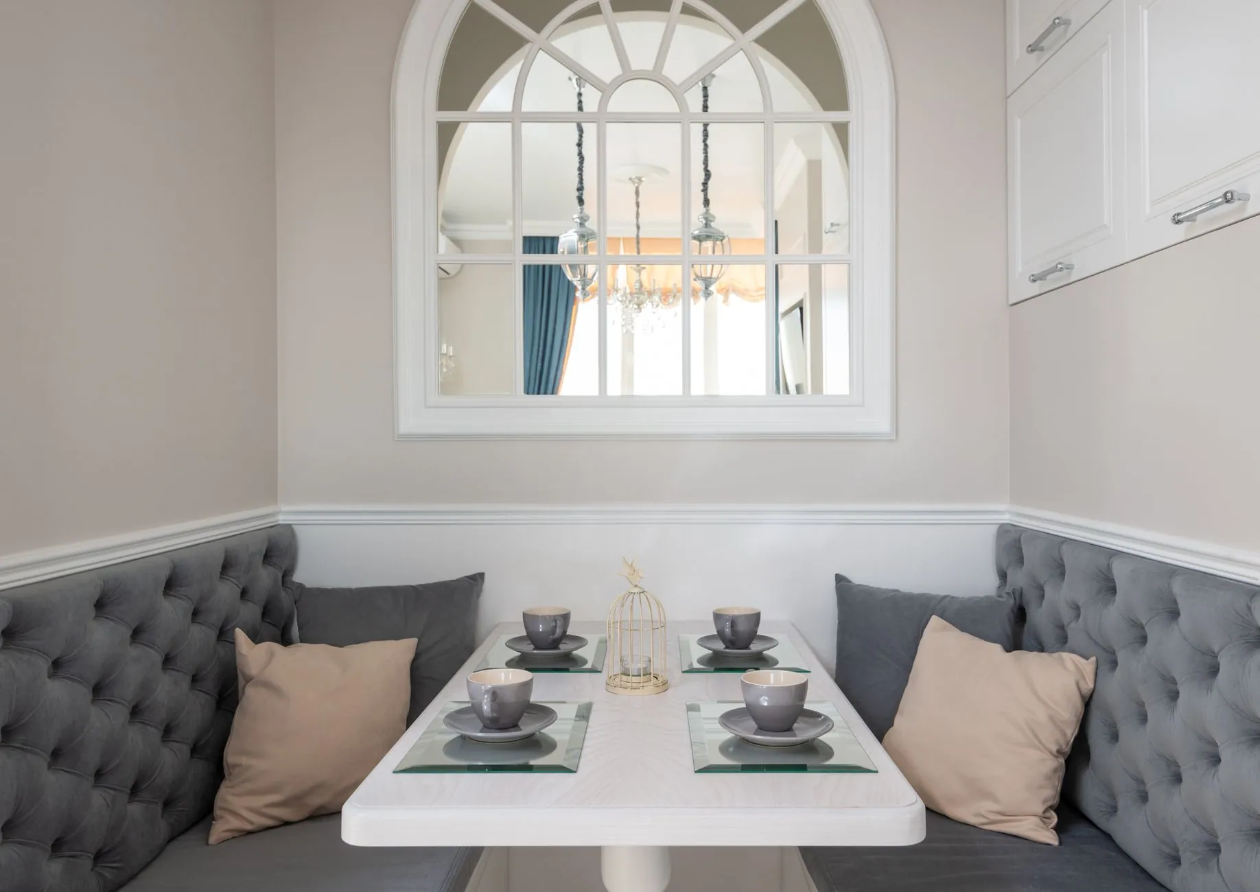 Dining nook with upholstered bench seating beside a table set for four