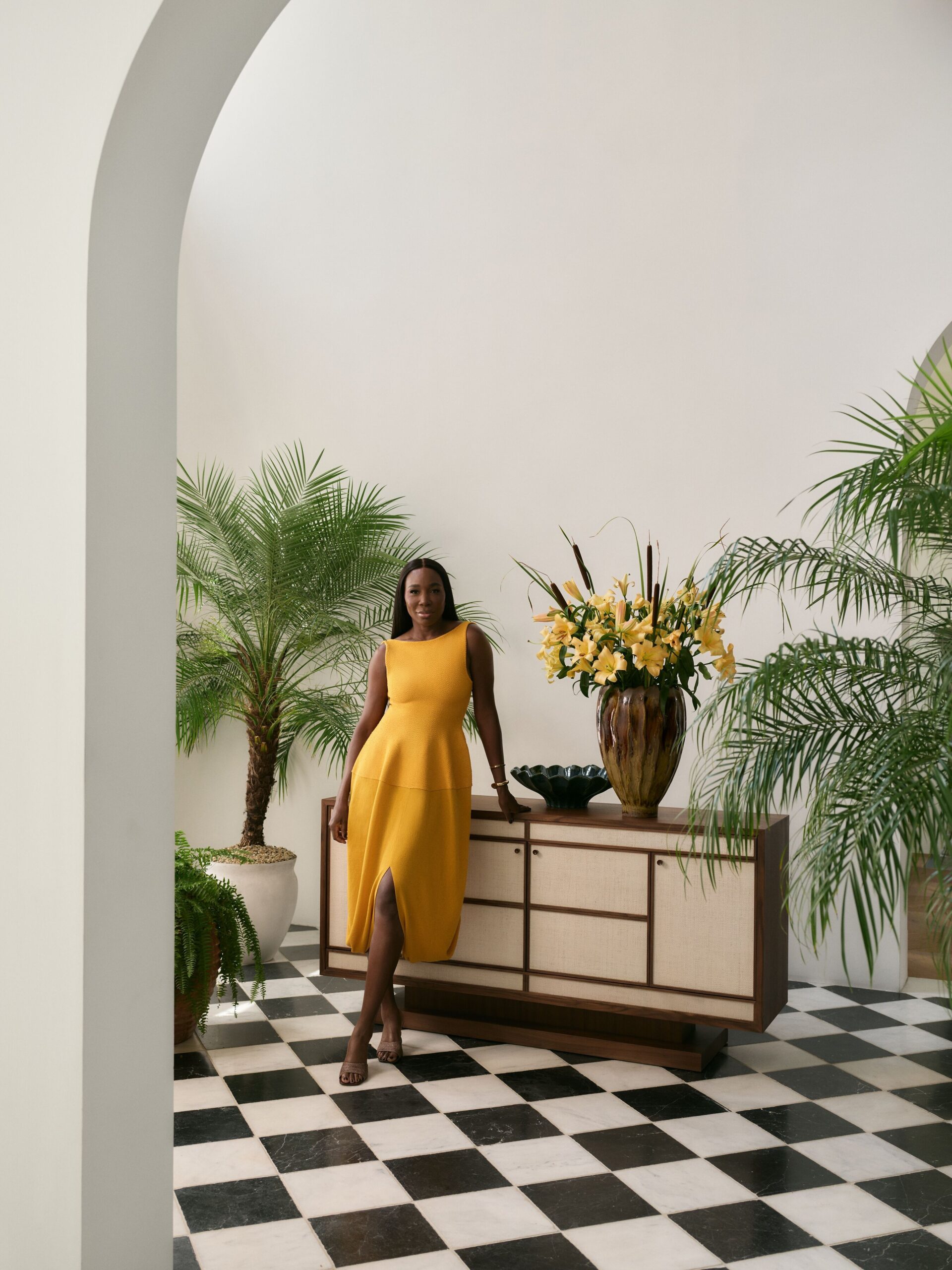 Venus Williams in a yellow dress beside a cabinet from her Crate and Barrel collection