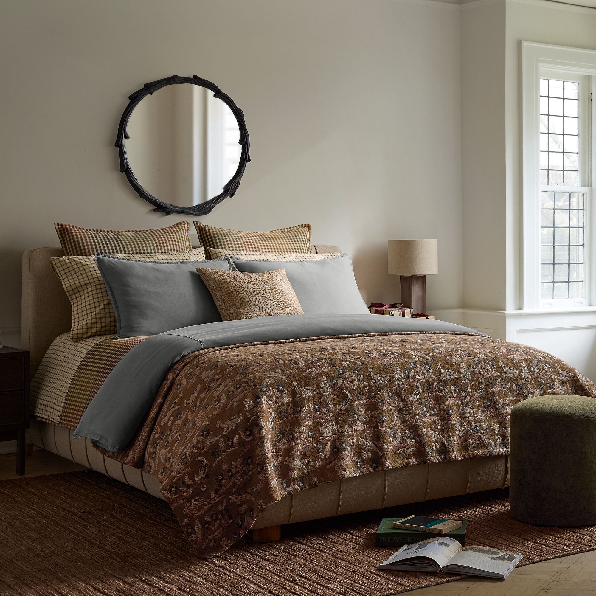 Lone Fox Forest Jacquard Tapestry Blanket on a bed layered with plaid and check bedding