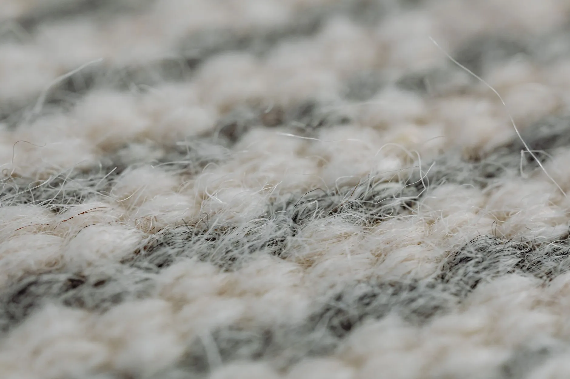 Close-up of cream and gray wool rug fibers