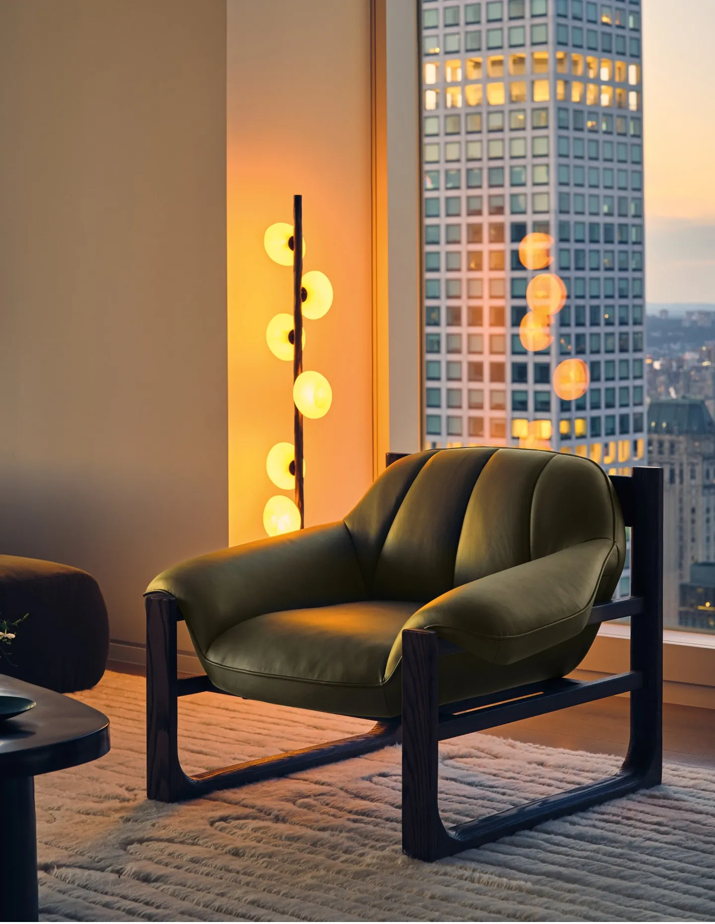 Green leather Casa Dean accent chair beside a sculptural floor lamp