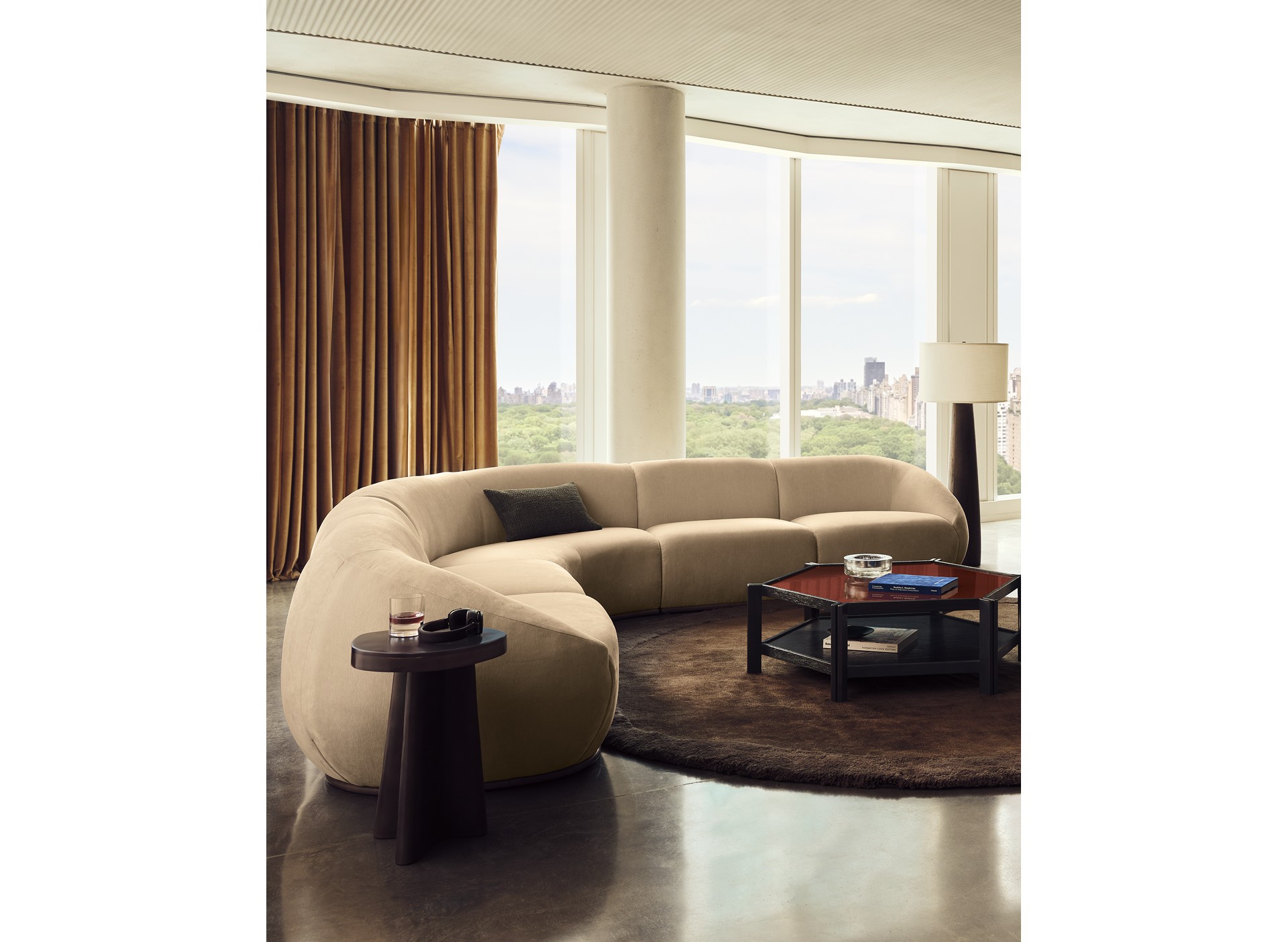 Ivory curved sectional from Casa Dean arranged around a dark coffee table