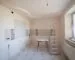 Unfinished kitchen with a ladder, worktable, and exposed service points