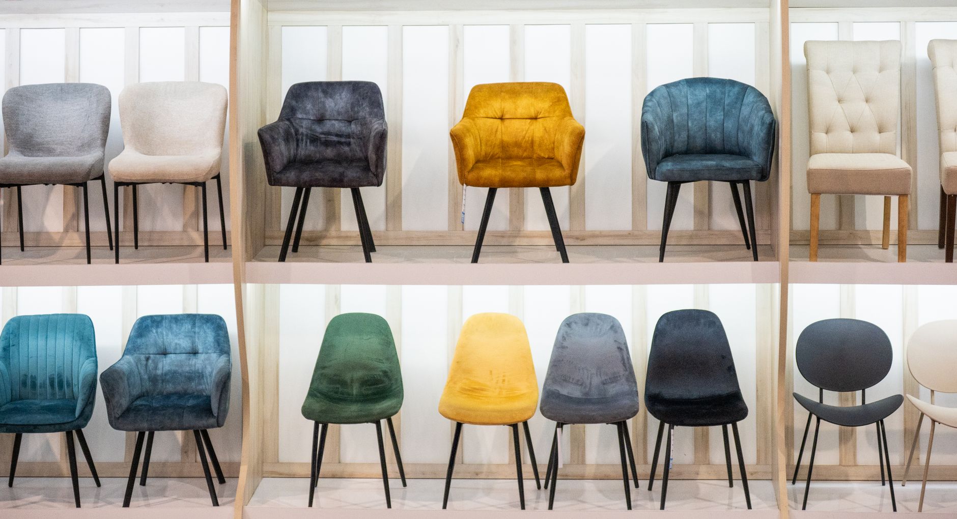 Upholstered dining chairs in different colors and shapes on display
